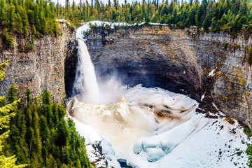 The spectacular ice and snow cone in winter at the bottom of Helmcken Falls on the Murtle River in...