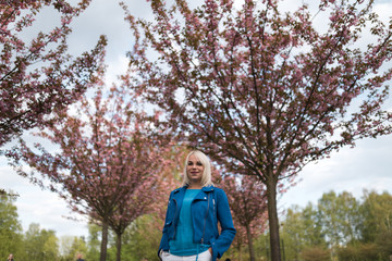 Young blonde mother woman enjoying free time - Dressed in blue jacket and white pants