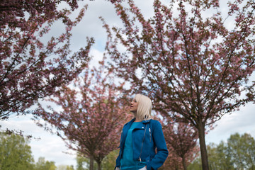 Young blonde mother woman enjoying free time - Dressed in blue jacket and white pants