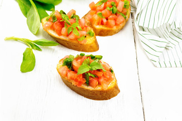 Bruschetta with tomato and spinach on table