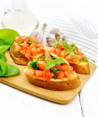 Acrylic prints Restaurant Bruschetta with tomato and spinach on light wooden table