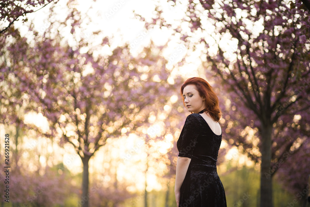 Wall mural Happy young travel dancer woman enjoying free time in a sakura cherry blossom park - Caucasian white redhead girl - Dressed black chocker, black dress and black golfs