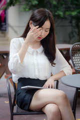 portrait of thai china adult office girl white shirt using her tablet.