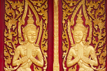 Thai buddhism angle in gold colour on red colour wood windows decorations of Thai Buddhism Temple. Songkhla city Thailand.