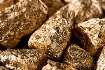 close up view of golden textured shiny stones in daylight