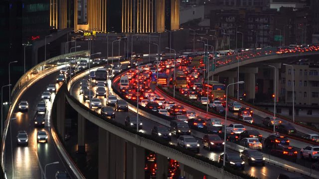 Traffic jam in the rush hour on highway. Cars on bridges and roads in Shanghai Downtown, China at night.