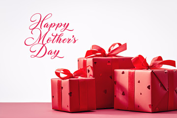 Happy Mother's Day! Gift boxes in red paper with hearts , decorated with ribbon. Concept of...