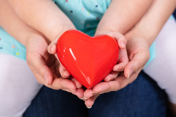 Mother And Daughter Holding Red Heart