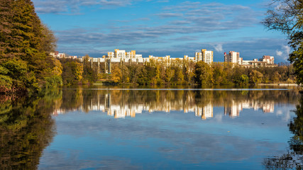 reflection of trees and houses in the lake