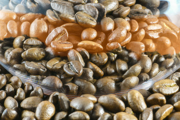 Close-up of roasted coffee beans and a glass glass Cup is next. Horizontal photography