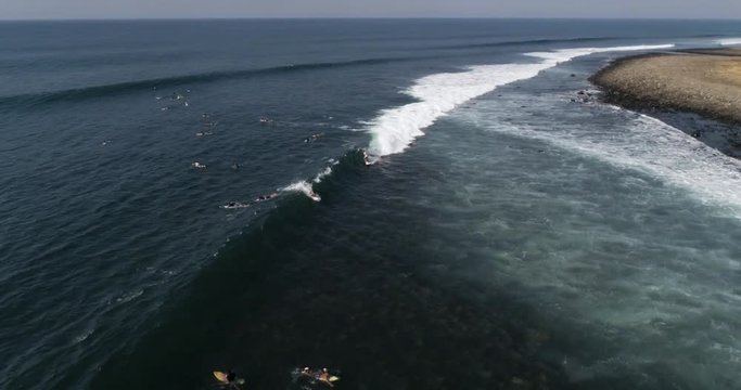 Surfers riding waves in tropical beach with young man sports. High angle aerial drone video of lifestyle slow motion stock clip with Airflow Creations.