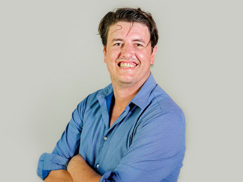 isolated portrait of young attractive and confident entrepreneur man in casual shirt smiling happy and positive looking at the camera in business success