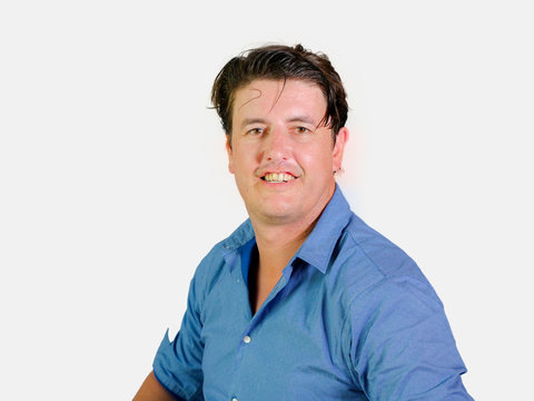 isolated portrait of young attractive and confident entrepreneur man in casual shirt smiling happy and positive looking at the camera in business success