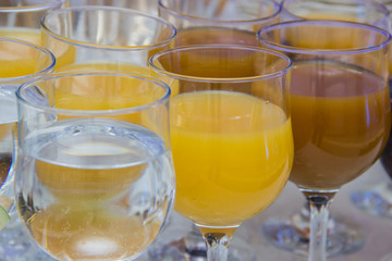 Closeup shot of glasses filled with water and juices on the table