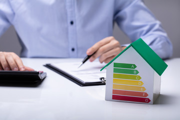 Small House With Energy Efficiency Rate On White Desk