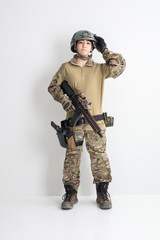 白背景に迷彩服を全身着たかっこいい女の子がエアーガンを持っているサバイバルゲームサバゲー体験 