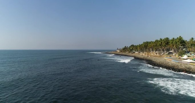 Tropical beach with palm trees. Surfers in the coastline. Airflow Creations travel slow motion.