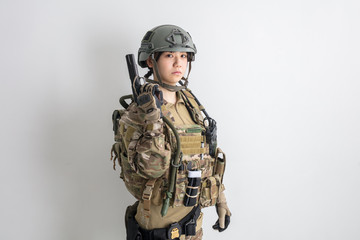 白背景に迷彩服を全身着たかっこいい女の子が銃を持っているサバイバルゲームサバゲー体験 