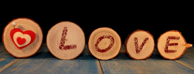 beautiful red heart is nailed to a wooden saw cut on a black background