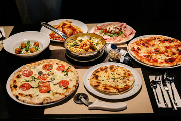 Hot served Italian dishes: Pizza Carbonara and Carpres with Pizza Cutter, Cold Cuts with Burrata Cheese, Puccia with Black Truffle and Linguini Seafood.