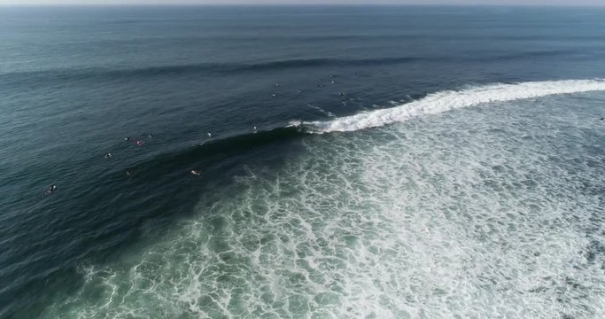 Surfers in the line up of tropical point break in Central America. Airflow creations travel and outdoor sports aerial. Surfers wating for waves. Dolly Slow Motion.