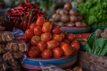 Fototapeta na wymiar Asian food ingredients corner. Organic fresh agricultural product at farmer market. Fresh tomatoes, onions, eggplant, are packaged in simple containers and displayed for sale at an produce stand.