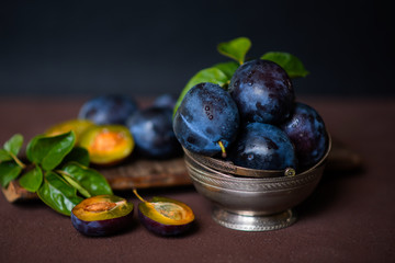 Bowl with ripe juicy plums on table. Fresh organic plums. Summer harvest. Autumn harvest. Beautiful still life. Toned image. Selective focus.