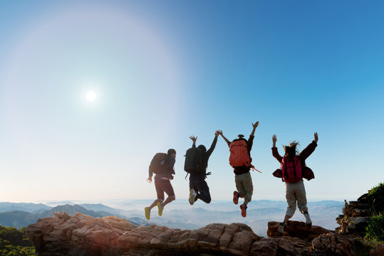 Group of happy hiker jumping on the hill
