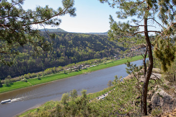 Fototapeta premium Saxon Switzerland - Germany main attraction. View from Bastei in view of a German town, sandy cliffs and the river Elbe on a sunny spring day