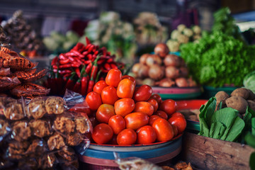 Asian food ingredients corner. Organic fresh agricultural product at farmer market. Fresh tomatoes, onions, eggplant, are packaged in simple containers and displayed for sale at an produce stand.