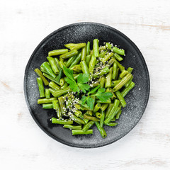 Boiled Green Asparagus Bean. In a black plate. Top view. Free copy space.