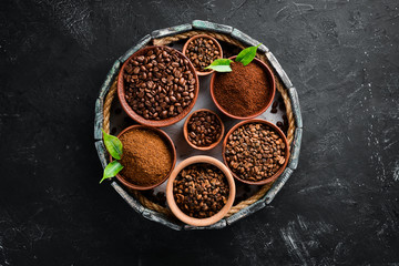 Ground coffee and coffee beans. Assortment of coffee varieties on a black background. Top view. Free space for your text.
