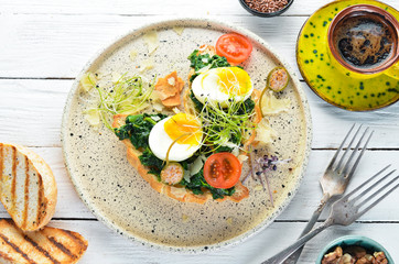 Sandwich with spinach, egg and tomatoes. croissant. Breakfast. In the plate. Top view. Flat lay composition Free copy space.