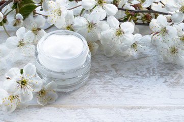 Fototapeta na wymiar Natural face cream with spring flowers, cherries.