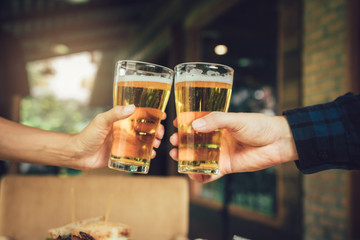 Teenager friends toasting and clinking with glass of beer.