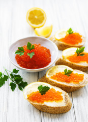 Red caviar in bowl and sandwiches