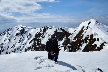 Fototapeta na wymiar tourist mountaineer on the top of a snow-covered mountain