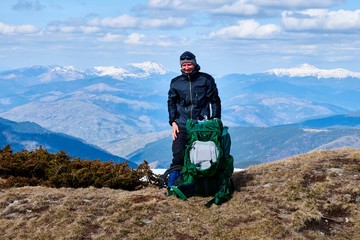 Obraz premium tourist mountaineer on the top of a snow-covered mountain