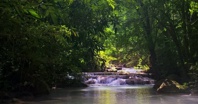 Beauty of tropical forest. Water stream with cascades under dense vegetation of Thailand jungle