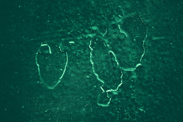 Vintage green background. Rough painted wall of emerald color. Imperfect plane of virid colored. Uneven old decorative toned backdrop of green tint. Texture of emerald hue. Ornamental stony surface.