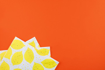 Lemon-patterned napkins on red background. Spring concept with copy space.