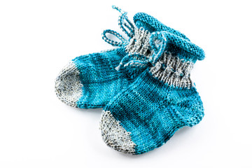 Knitted blue baby shoes isolated on white background