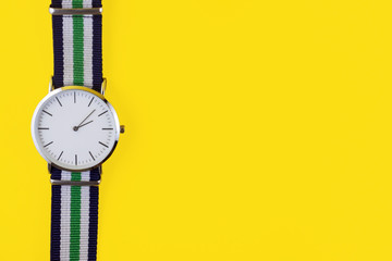 Modern watch on yellow background with copy space
