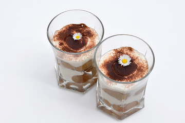 Romantic tiramisu dessert in a glass, decorated with daisies
