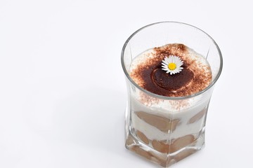 Romantic tiramisu dessert in a glass, decorated with daisies