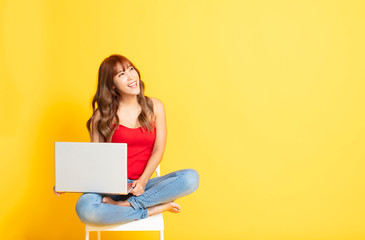smiling young woman holding laptop computer