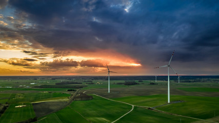 Fototapeta na wymiar Flying above wonderful wind turbines at dusk, Poland