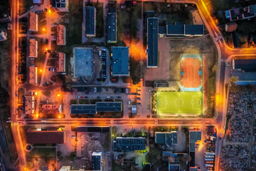 Sports field in small town at sunset, aerial view