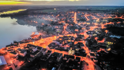 Flying above downtown by lake with smog at sunset, Poland