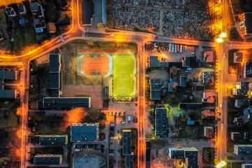 Small town and sports field at sunset, aerial view